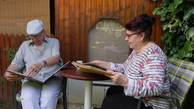 Senior couple look at their old photo album.