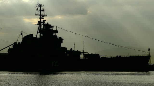 Silhouette of a warship of the Cold War at dawn