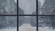 istock Silhouette of a wooden window overlooking the winter forest. Beautiful winter landscape with falling snow. 1171528465