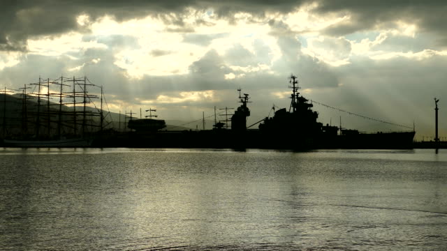 silhouettes of old ships at the pier on the background of dawn