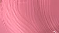istock Slow motion closeup water surface texture splash and ripples on pink background 1351241814