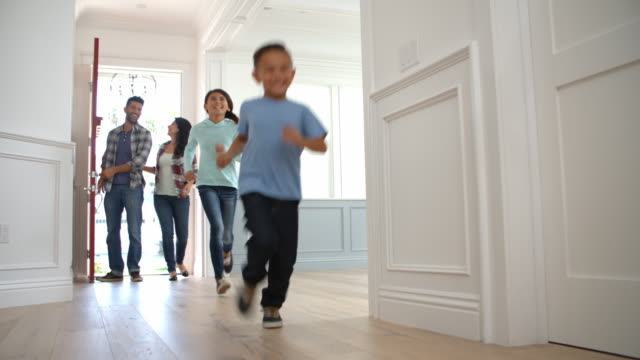 Slow Motion Shot Of Hispanic Family Moving Into New Home