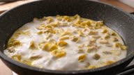 istock Slow motion Stir cooking sour cream Tortellini prosciutto Pasta in frying pan 1299386456