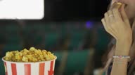 istock Smiling lovely blonde eating popcorn at the cinema 1340663409
