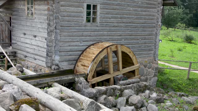 The wheel of an old water mill. A village mill, the wheel of which rotates under the influence of the force of water