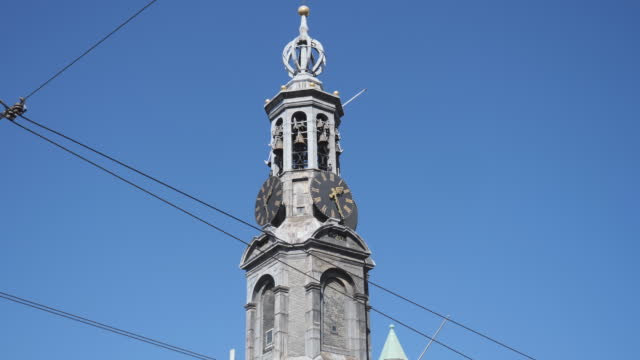 A tilt shot of a clock tower in Amsterdam.
