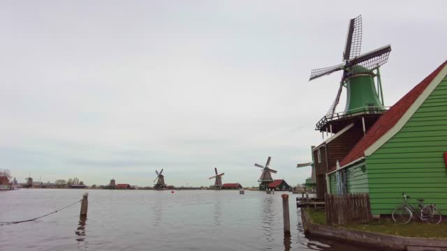 Traditional windmills over lake at the Zaanse Schans, cloudy weather