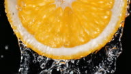 istock Water Pouring over the Backlit Juicy Orange Slice 1270463338