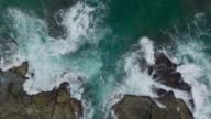 istock Waves crash against rocks in the ocean. A peaceful picture of nature. Aerial view of the rocks in water. The meeting place of the ocean and land. 120 fps video 1390724452
