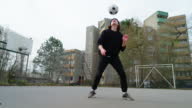 istock Young man juggles football on leg at urban soccer court 1388797842