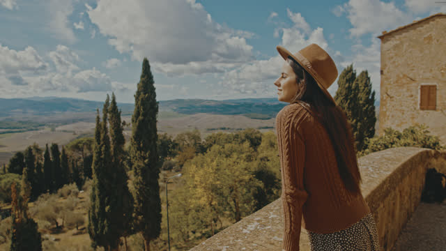 SLO MO Young woman enjoys the view from the city walls at Pienza