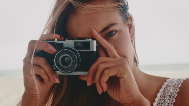 Young woman photographing through vintage camera